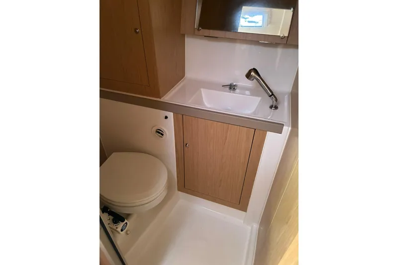 Slide: The Image of Beneteau Oceanis 41.1 2020 yacht bathroom with sink, toilet, and wooden cabinetry. - 15