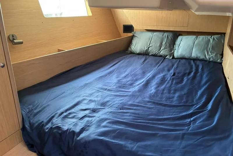 Slide: The Image of Cozy cabin interior of 2020 Beneteau Oceanis 41.1 with blue bedding and wooden finish. - 9