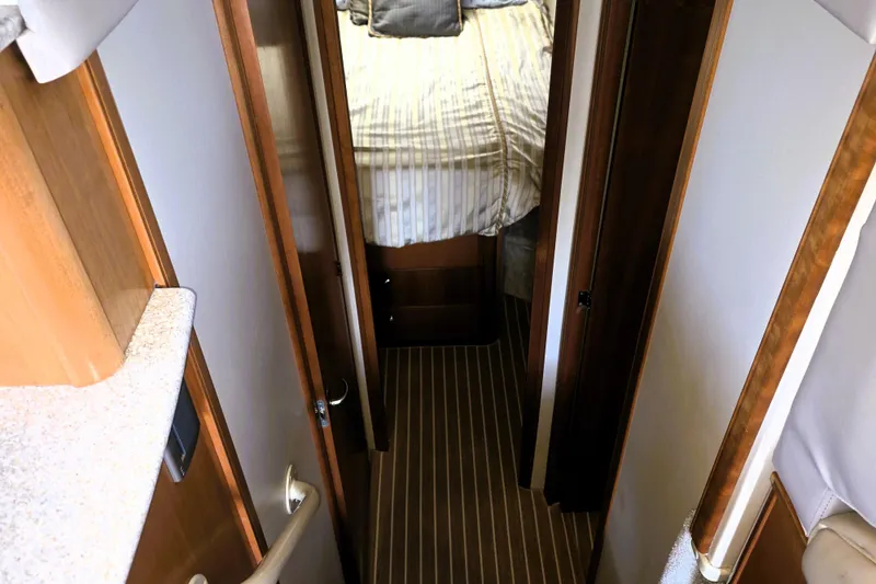 Slide: The Image of 2004 Meridian 391 Sedan interior hallway leading to bedroom with striped bedding. - 19