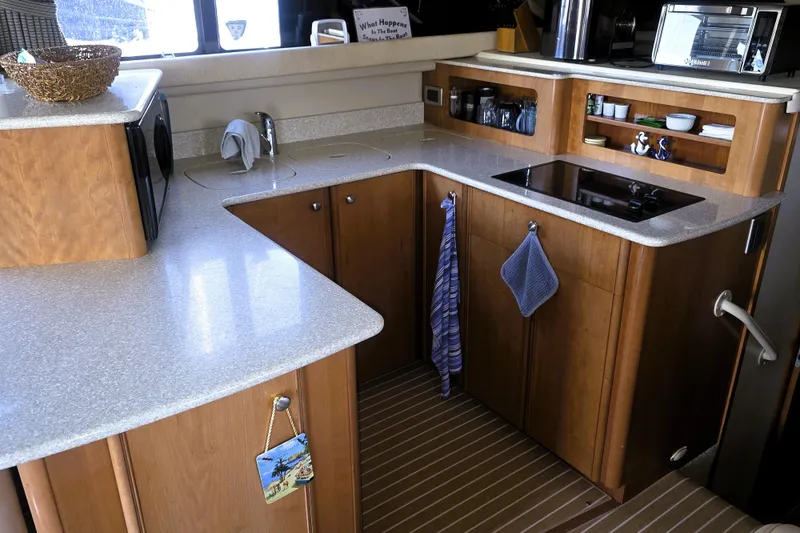 Slide: The Image of Compact kitchen in a 2004 Meridian 391 Sedan yacht with modern appliances and wooden cabinetry. - 4
