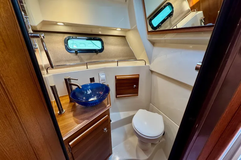 Slide: The Image of Luxurious 2024 Ranger Tugs R-27 bathroom with modern sink and elegant wood accents. - 15