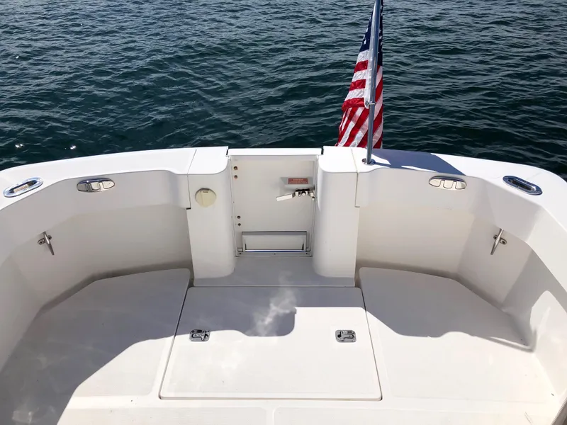 Slide: The Image of 2003 Mainship 30 Pilot II boat deck with American flag, overlooking calm water. - 10