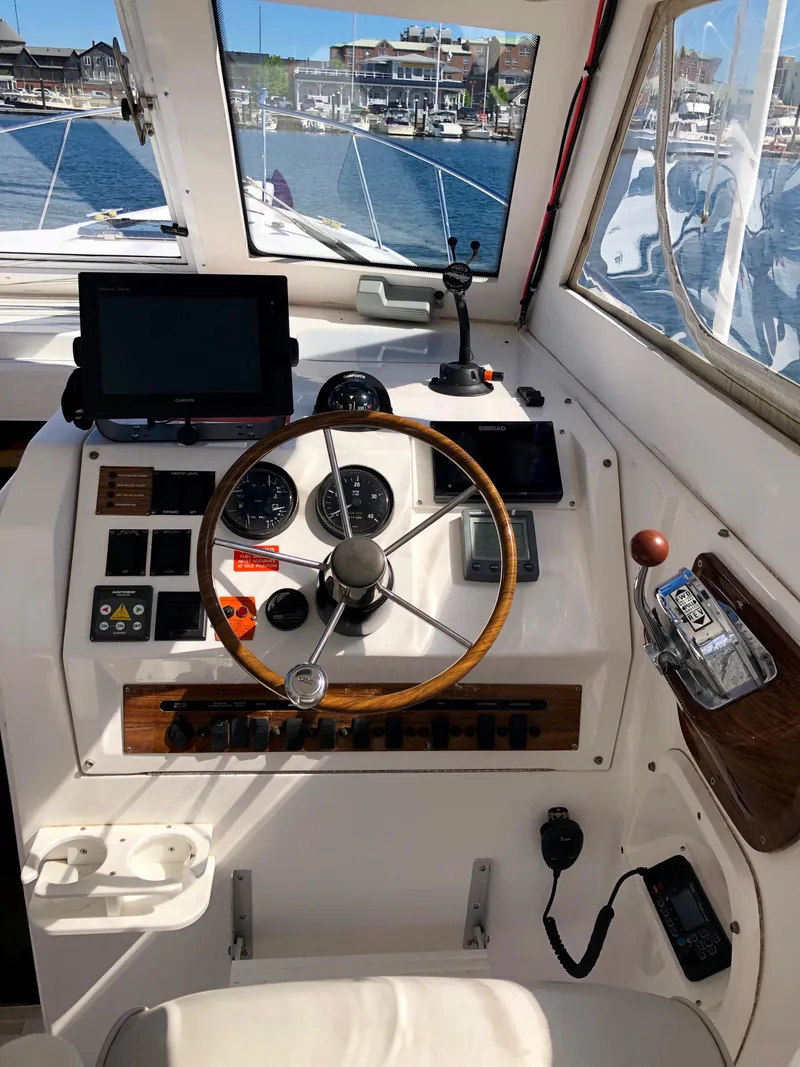 Slide: The Image of 2003 Mainship 30 Pilot II Hardtop helm with steering wheel and navigation instruments. - 16