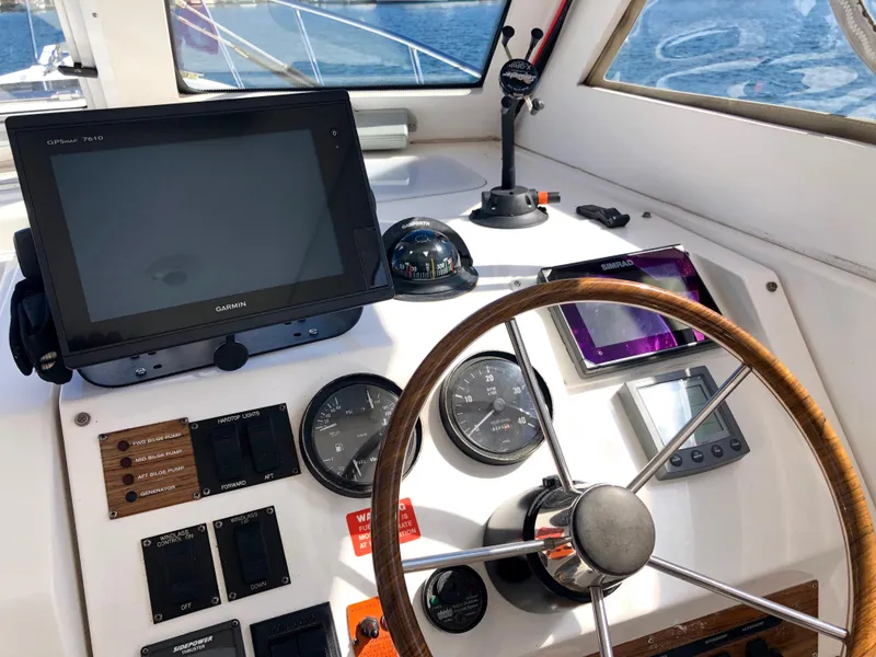 Slide: The Image of 2003 Mainship 30 Pilot II helm with navigation equipment and wooden steering wheel. - 17