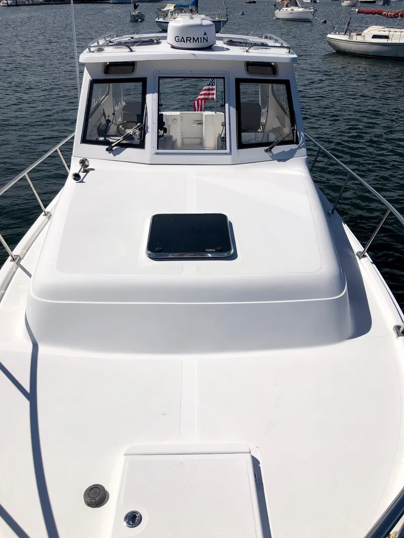 Slide: The Image of 2003 Mainship 30 Pilot II Hardtop boat on water, featuring Garmin equipment. - 20