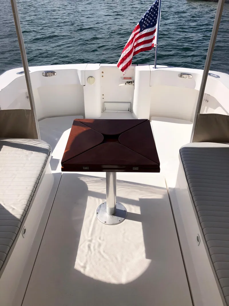 Slide: The Image of 2003 Mainship 30 Pilot II Hardtop boat interior with table and American flag. - 22