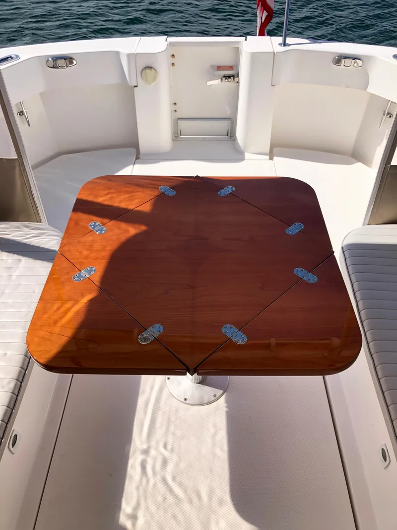 Slide: The Image of 2003 Mainship 30 Pilot II boat with wooden table on deck. - 23