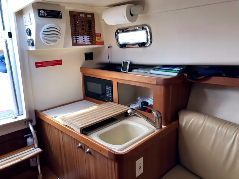 Slide: The Image of 2003 Mainship 30 Pilot II boat interior with kitchenette, sink, and microwave. - 28
