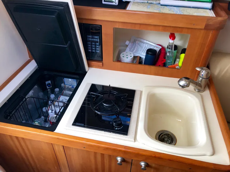 Slide: The Image of 2003 Mainship 30 Pilot II galley with stove, sink, and storage. - 29