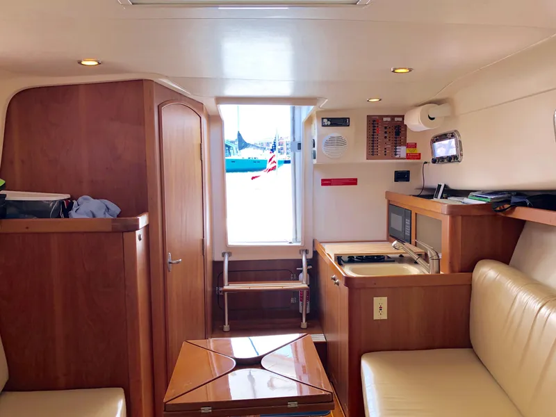 Slide: The Image of 2003 Mainship 30 Pilot II interior with wood finish, kitchenette, and seating area. - 30