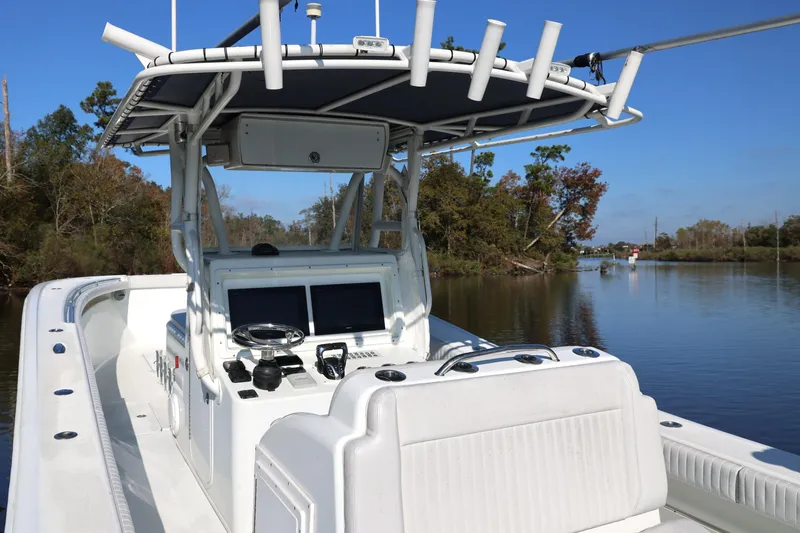 Slide: The Image of 2006 Yellowfin 36 Offshore boat with dual screens, navigating a calm river. - 13