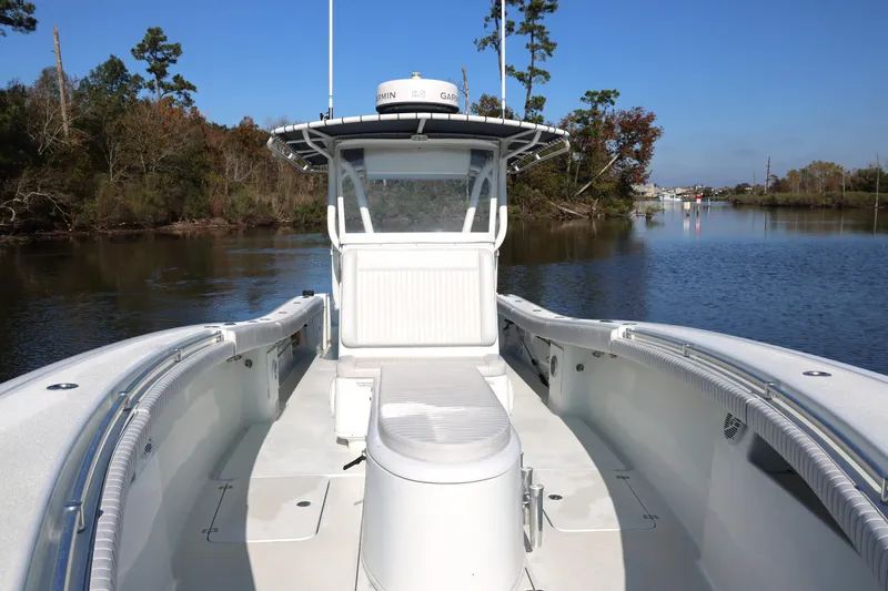 Slide: The Image of 2006 Yellowfin 36 Offshore boat on calm river, clear sky, surrounded by trees. - 16