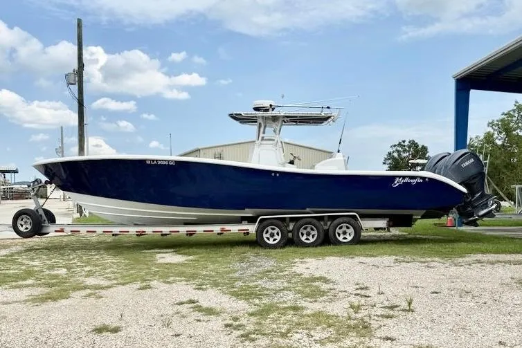 Slide: The Image of 2006 Yellowfin 36 Offshore boat on calm water, surrounded by lush greenery. - 2