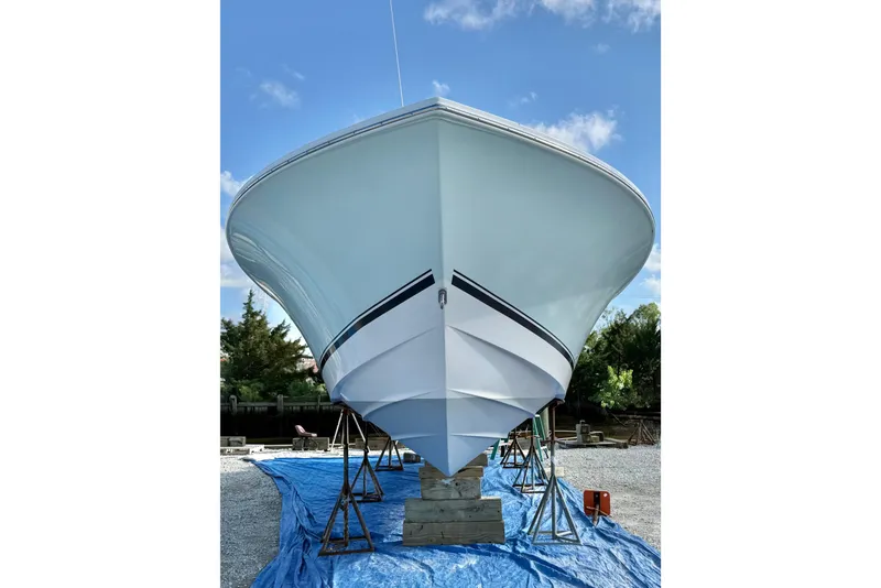 Slide: The Image of 2006 Regulator 32 Forward Seating boat on stands, viewed from the front, outdoors. - 13