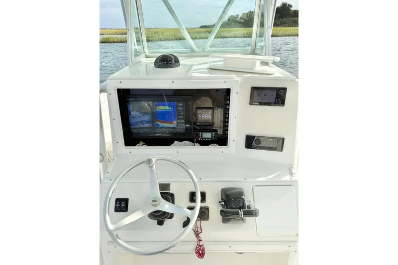 Slide: The Image of 2006 Regulator 32 Forward Seating boat dashboard with navigation equipment and steering wheel. - 14