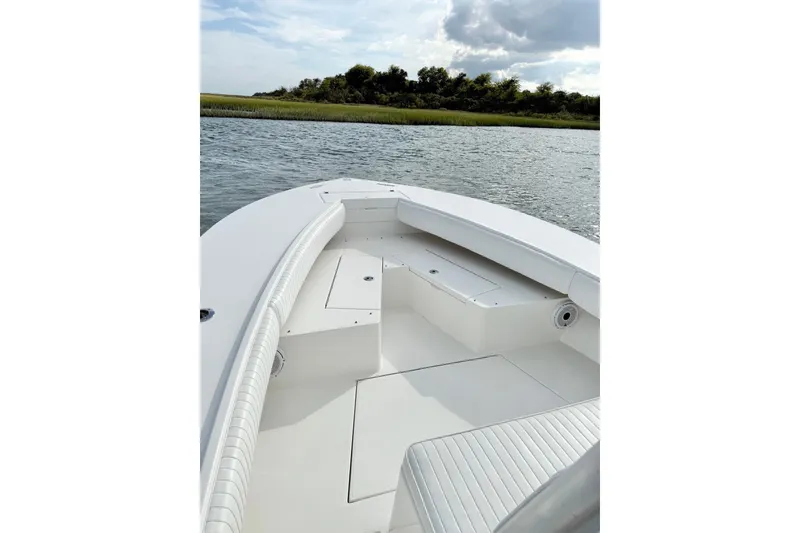 Slide: The Image of 2006 Regulator 32 Forward Seating boat on calm water, featuring spacious deck and seating. - 15