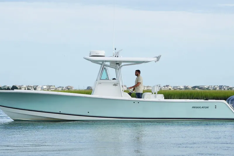 Slide: The Image of 2006 Regulator 32 Forward Seating boat on calm water with scenic background. - 3