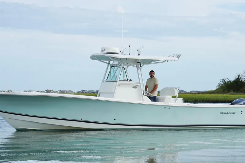 Slide: The Image of 2006 Regulator 32 Forward Seating boat on calm water with a person at the helm. - 5