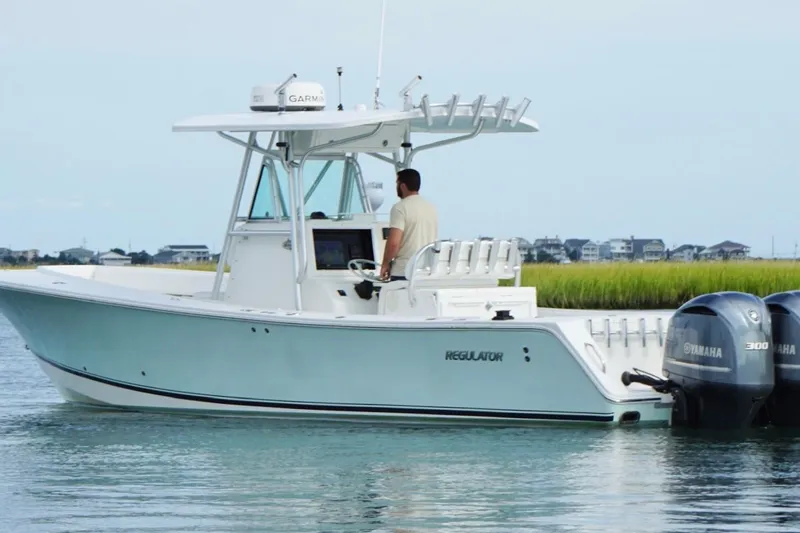 Slide: The Image of 2006 Regulator 32 Forward Seating boat with dual Yamaha engines on calm water. - 9