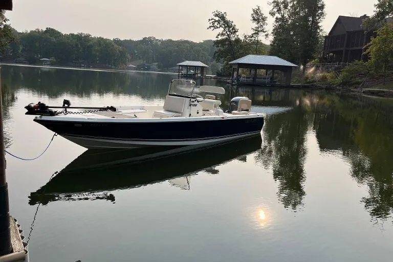 Slide: The Image of Century 2102 boat from 2007 on a serene lake with docked boathouses. - 4