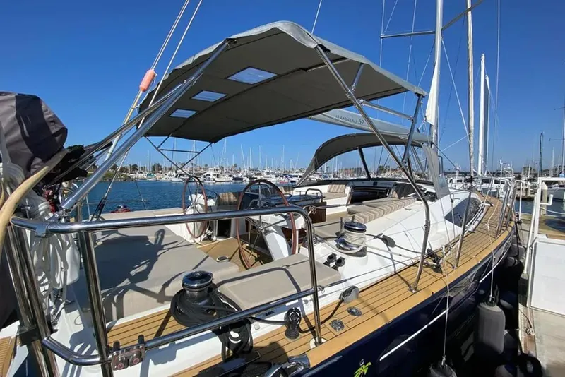Slide: The Image of 2013 Jeanneau 57 yacht deck with sleek wooden finish and clear blue sky. - 12