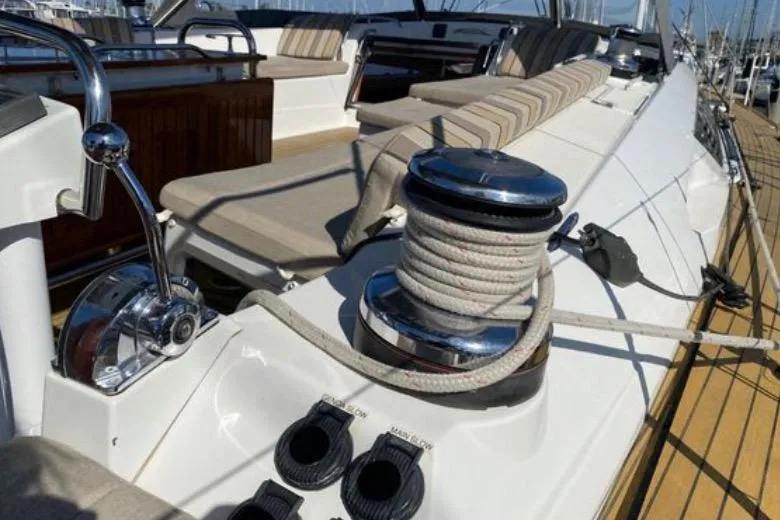 Slide: The Image of 2013 Jeanneau 57 yacht cockpit with dual steering wheels, docked in a marina. - 16
