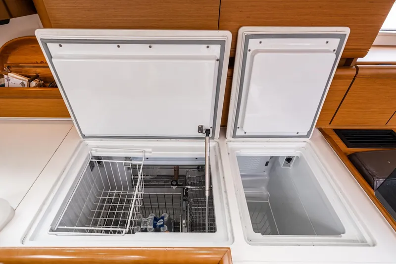 Slide: The Image of Open storage compartments on a 2013 Jeanneau 57 yacht, featuring deck and equipment. - 22