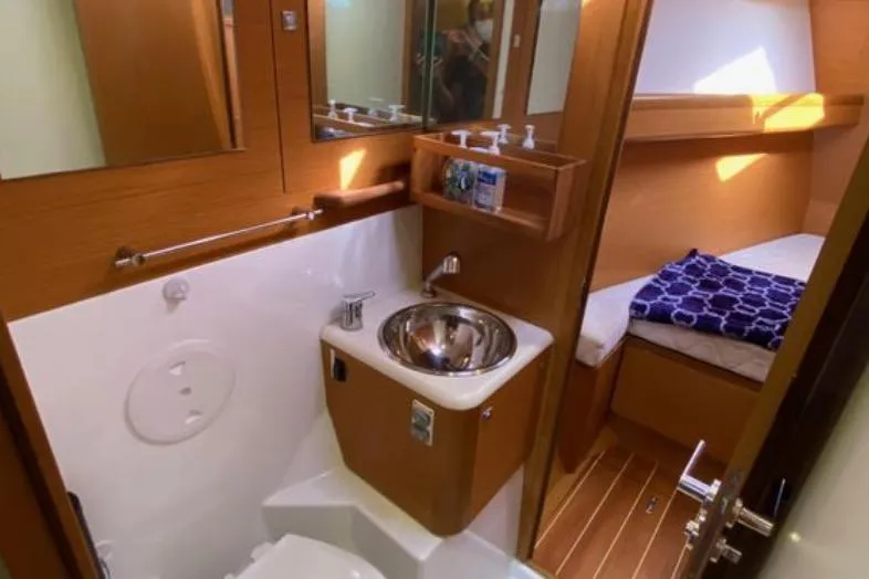Slide: The Image of 2013 Jeanneau 57 yacht interior cabin with wooden cabinetry and cozy seating. - 45