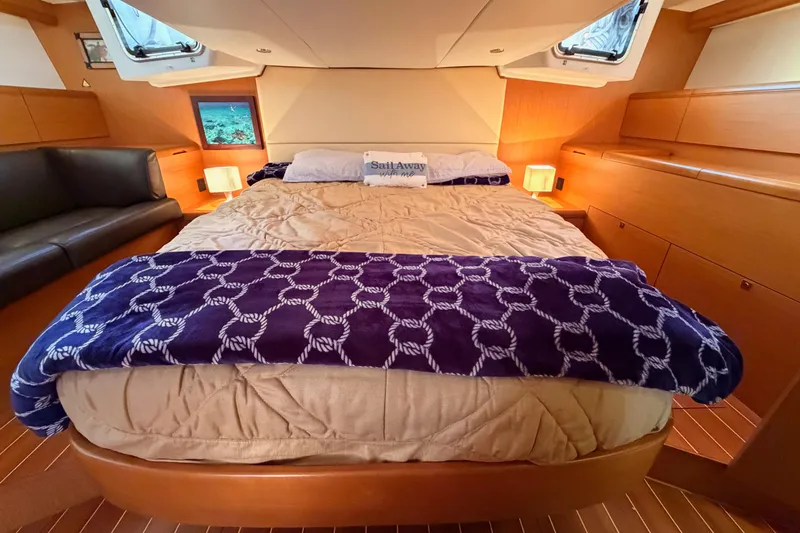 Slide: The Image of Luxurious cabin interior of a 2013 Jeanneau 57 yacht with cozy bedding and elegant decor. - 58