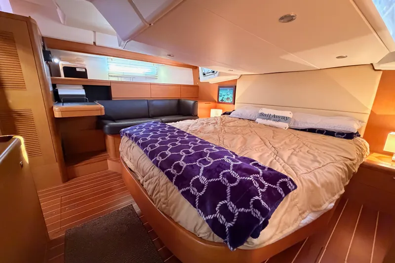 Slide: The Image of Luxurious interior of a 2013 Jeanneau 57 yacht with cozy bedding and elegant wood finishes. - 62
