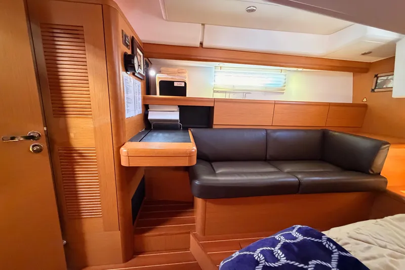 Slide: The Image of Interior of 2013 Jeanneau 57 yacht with wooden finish and black leather seating. - 63