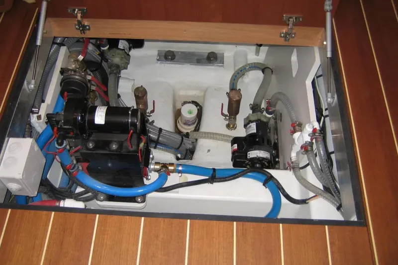 Slide: The Image of Engine compartment of a 2013 Jeanneau 57 yacht, showcasing mechanical components and wiring. - 66