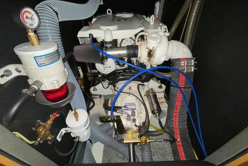 Slide: The Image of Engine compartment of a 2013 Jeanneau 57 yacht, showcasing mechanical components and hoses. - 72