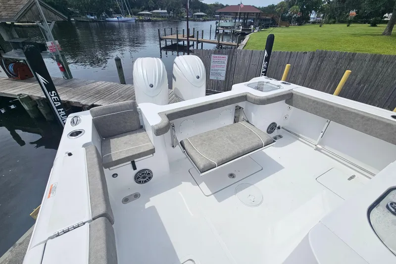 Slide: The Image of 2025 Sea Hunt Gamefish 27 boat with forward seating, docked by a serene waterfront. - 11