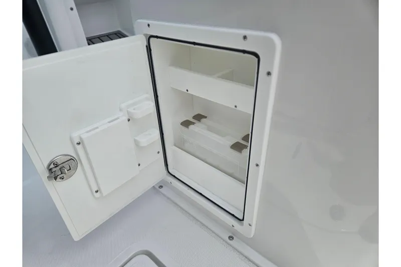 Slide: The Image of 2025 Sea Hunt Gamefish 27 storage compartment with open door and secure latch. - 14