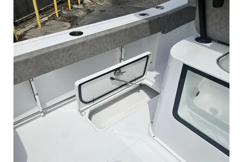 Slide: The Image of 2025 Sea Hunt Gamefish 27 Forward Seating boat interior with storage compartment open. - 16