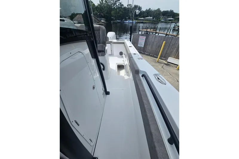 Slide: The Image of 2025 Sea Hunt Gamefish 27 Forward Seating boat docked by a serene waterfront. - 18