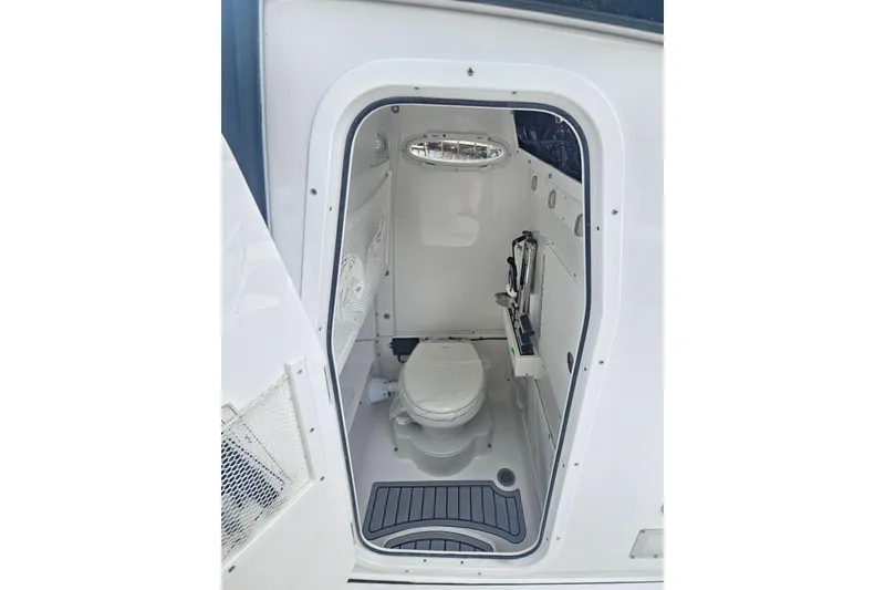 Slide: The Image of 2025 Sea Hunt Gamefish 27 Forward Seating boat interior with compact marine toilet. - 19
