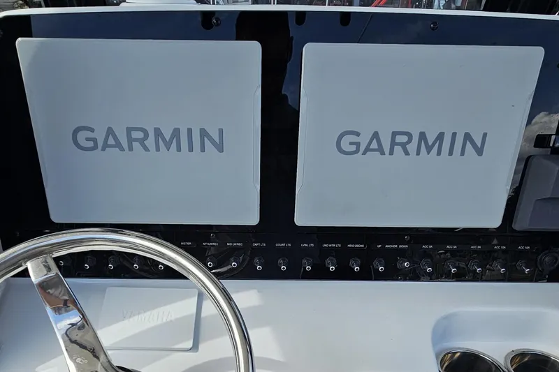 Slide: The Image of 2025 Sea Hunt Gamefish 27 dashboard with dual Garmin displays and Yamaha steering wheel. - 24