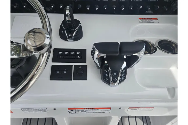 Slide: The Image of 2025 Sea Hunt Gamefish 27 Forward Seating helm with modern controls and steering wheel. - 25