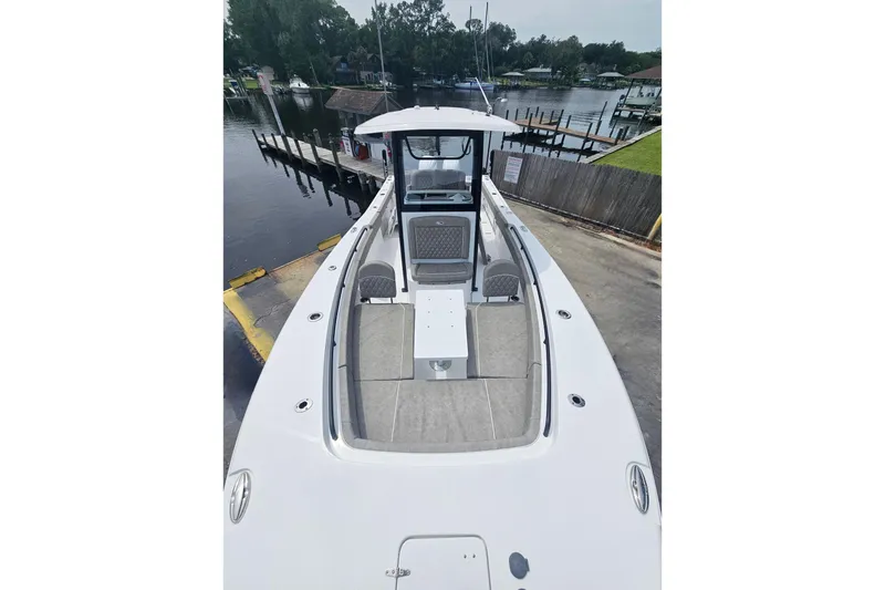 Slide: The Image of 2025 Sea Hunt Gamefish 27 Forward Seating boat docked by a serene waterfront. - 28