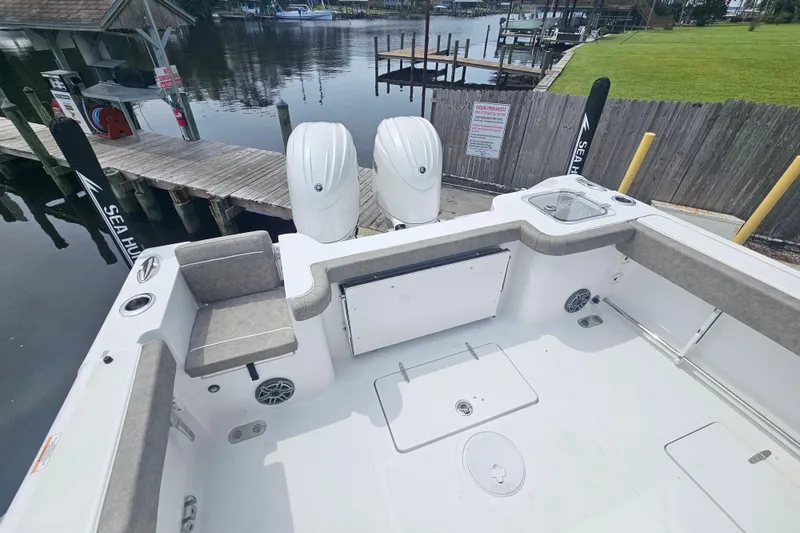 Slide: The Image of 2025 Sea Hunt Gamefish 27 boat with forward seating, docked by a wooden pier. - 33
