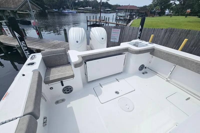 Slide: The Image of 2025 Sea Hunt Gamefish 27 boat with forward seating, docked by a serene waterfront. - 8