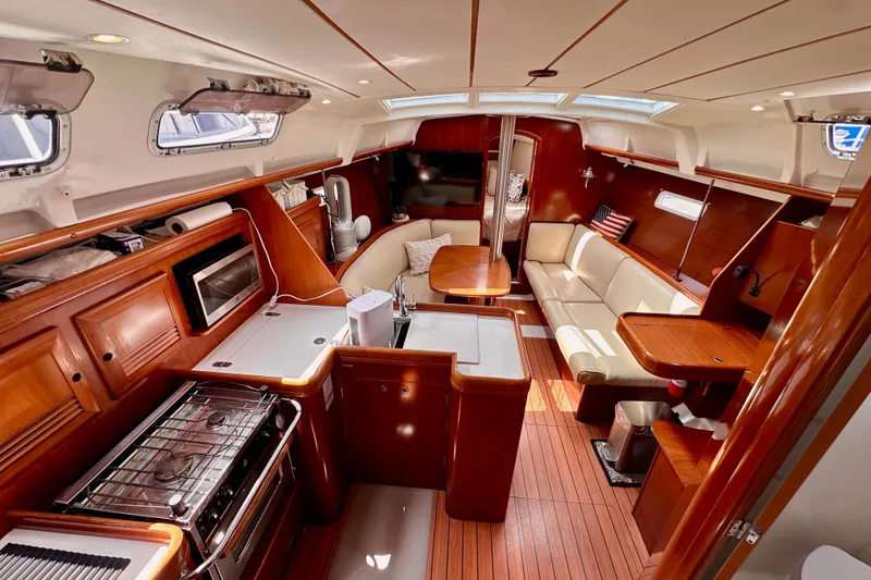 Slide: The Image of 2005 Beneteau Oceanis Clipper 373 interior with wood finish, kitchen, and seating area. - 12