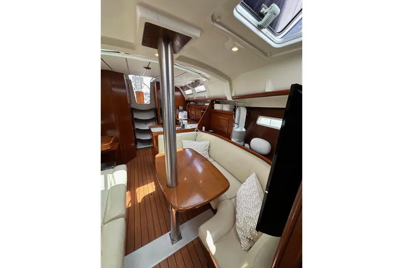 Slide: The Image of Interior of 2005 Beneteau Oceanis Clipper 373 sailboat, featuring wood finishes and cozy seating. - 21