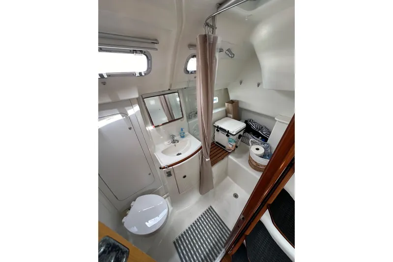 Slide: The Image of 2005 Beneteau Oceanis Clipper 373 bathroom with shower, sink, and toilet. - 24