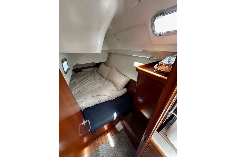 Slide: The Image of Cozy cabin interior of 2005 Beneteau Oceanis Clipper 373 sailboat with bed and wooden cabinetry. - 25