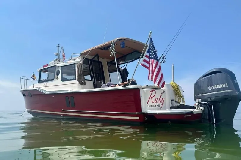 Slide: The Image of 2021 Ranger Tugs R-27 boat named Ruby with American flag, Yamaha motor, on calm water. - 3