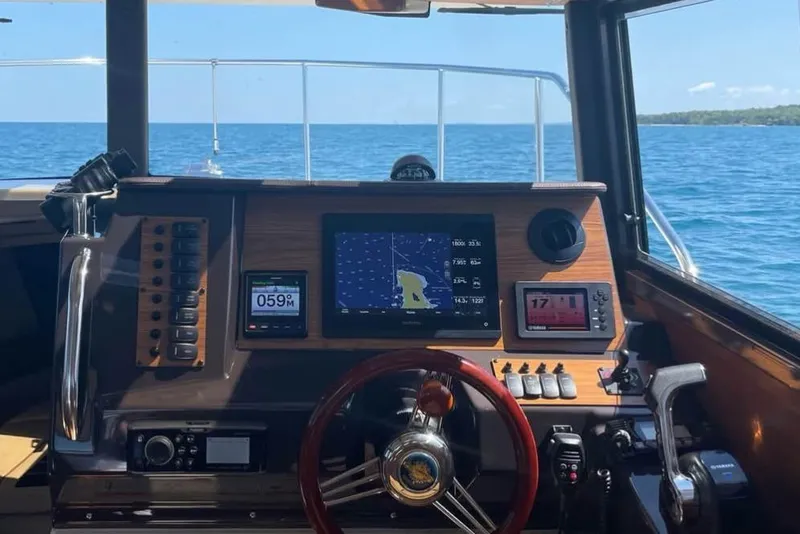 Slide: The Image of Cockpit view of 2021 Ranger Tugs R-27 with navigation screens and steering wheel. - 6