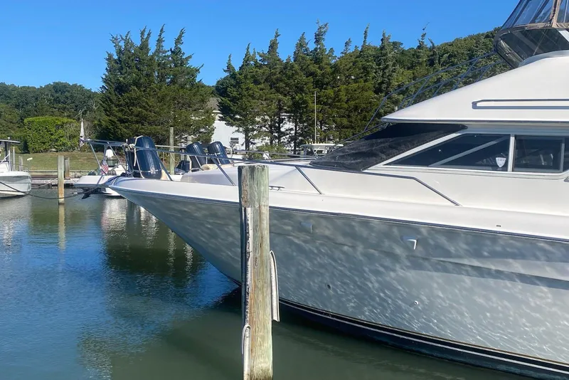 Slide: The Image of 1996 Sea Ray 440 Express Bridge yacht docked in a serene marina setting. - 2